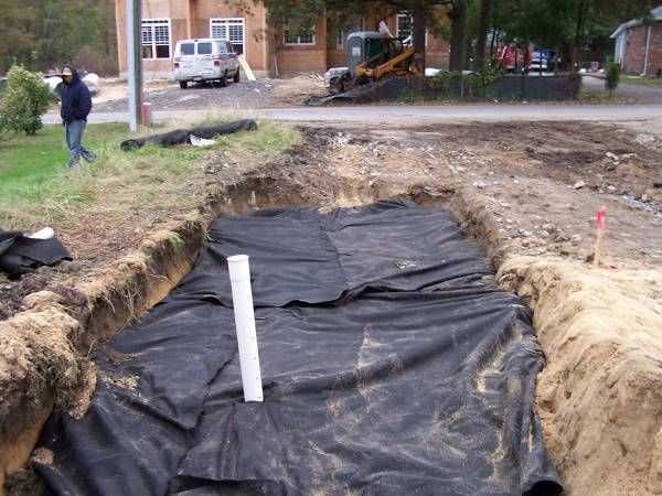 A large hole in the ground with a white pipe in it
