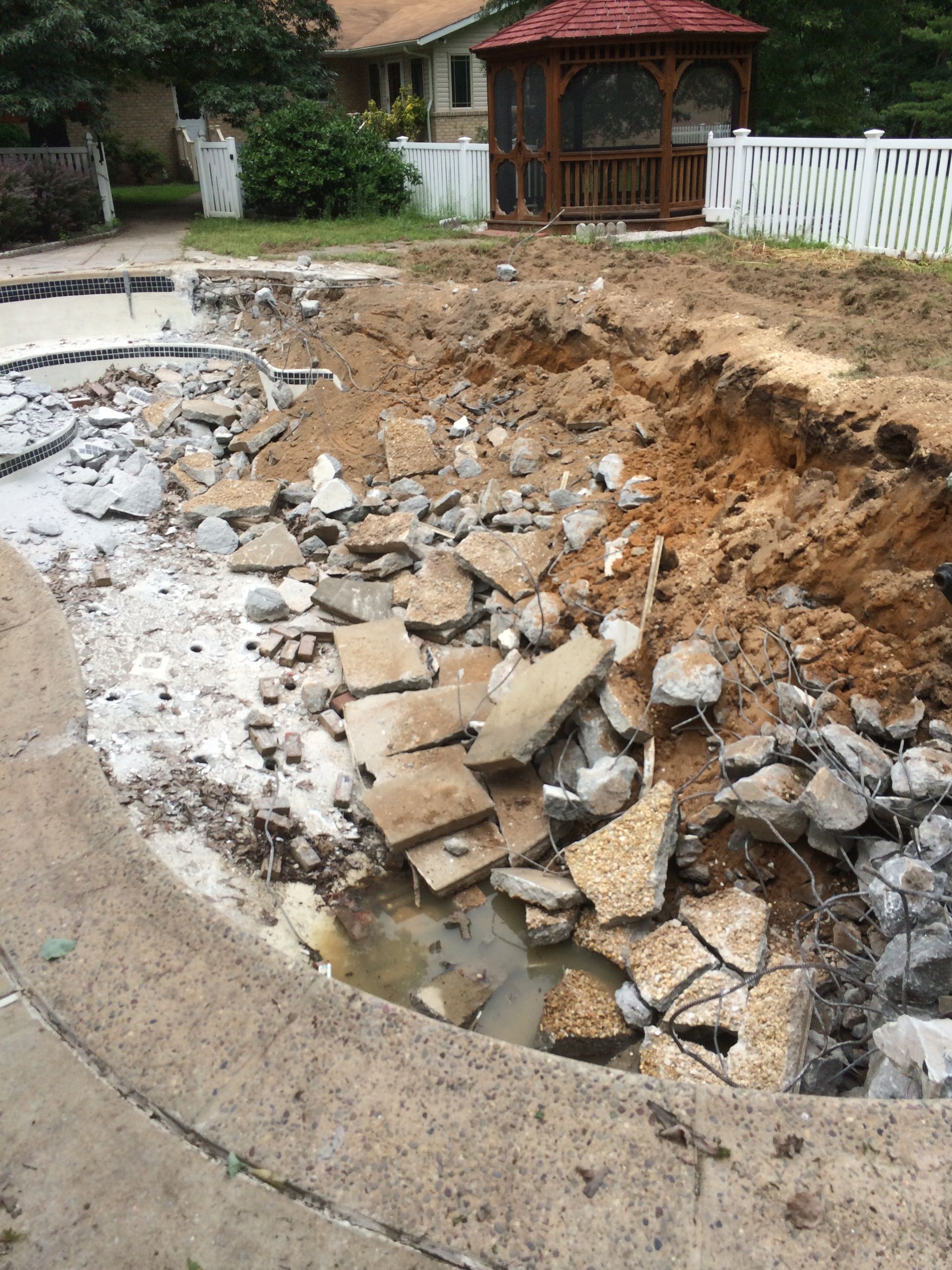 A large pile of rocks and dirt is sitting in front of a house.
