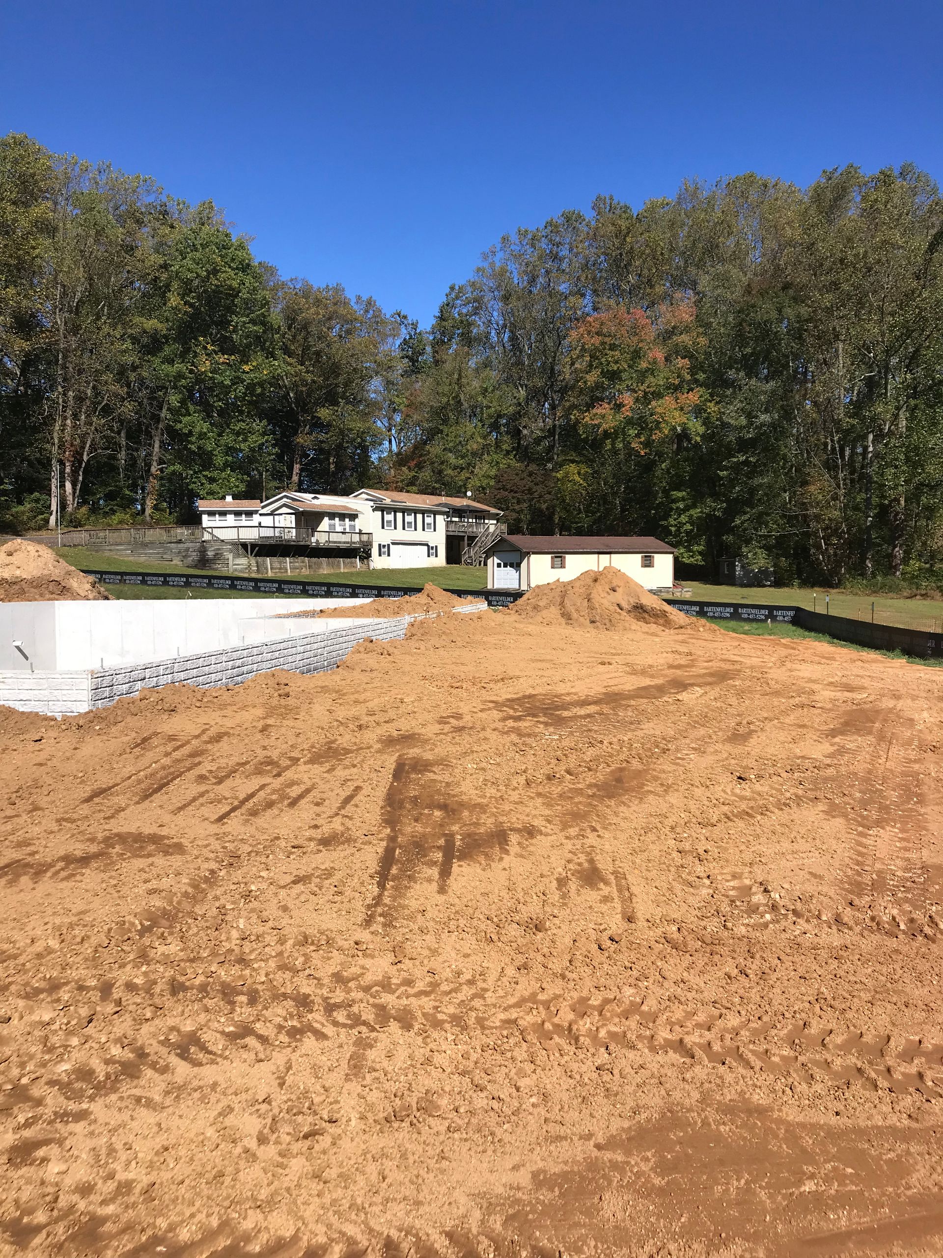 A large pile of dirt is sitting in front of a house.