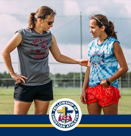 Female soccer coach teaching a young female athlete