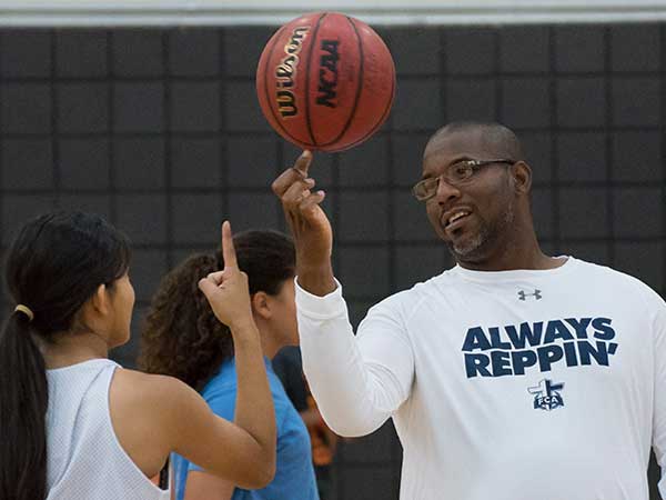 Character Coach teaching a student to spin a basketball