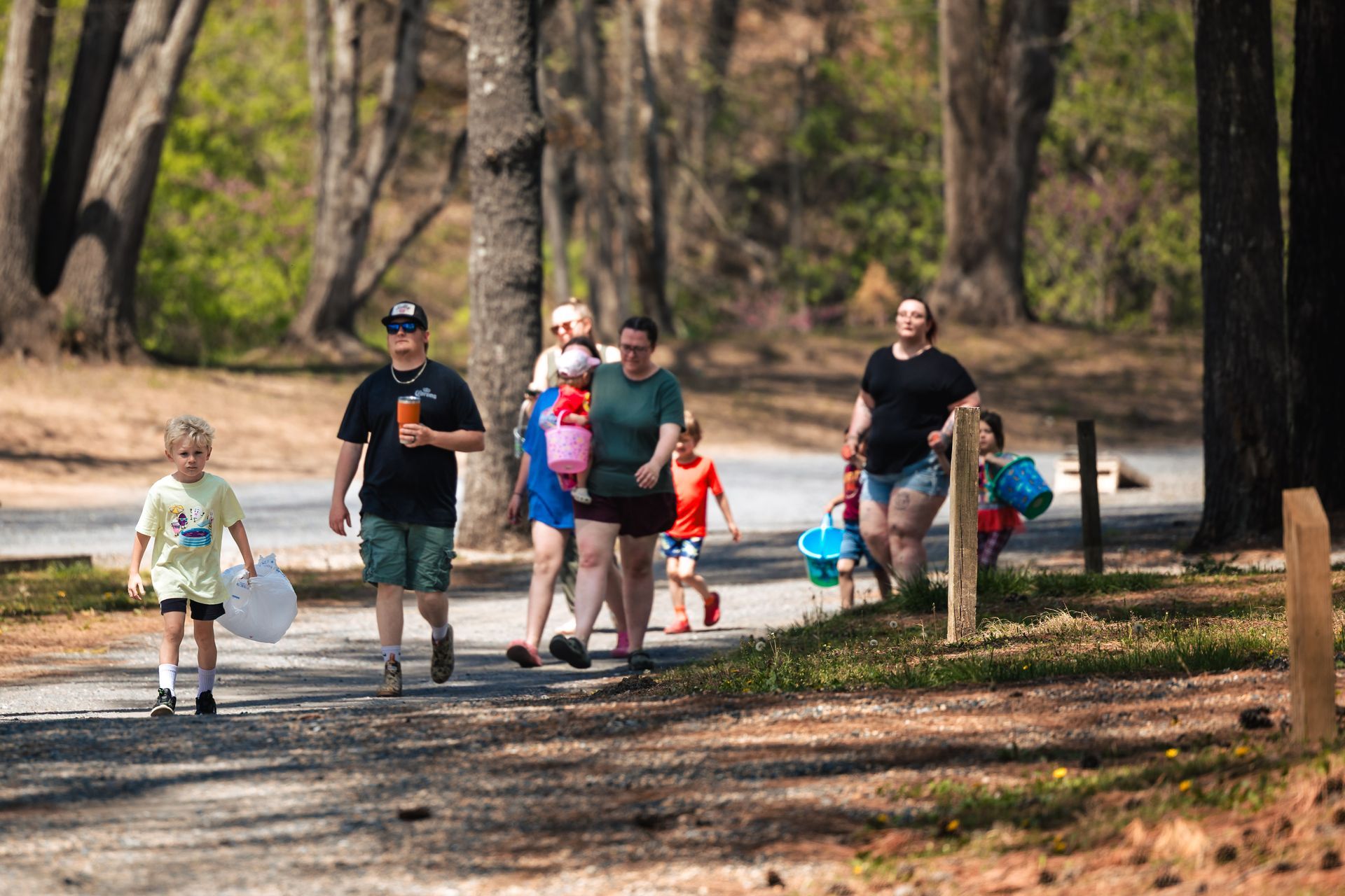 A group of people are walking down a path in the woods.