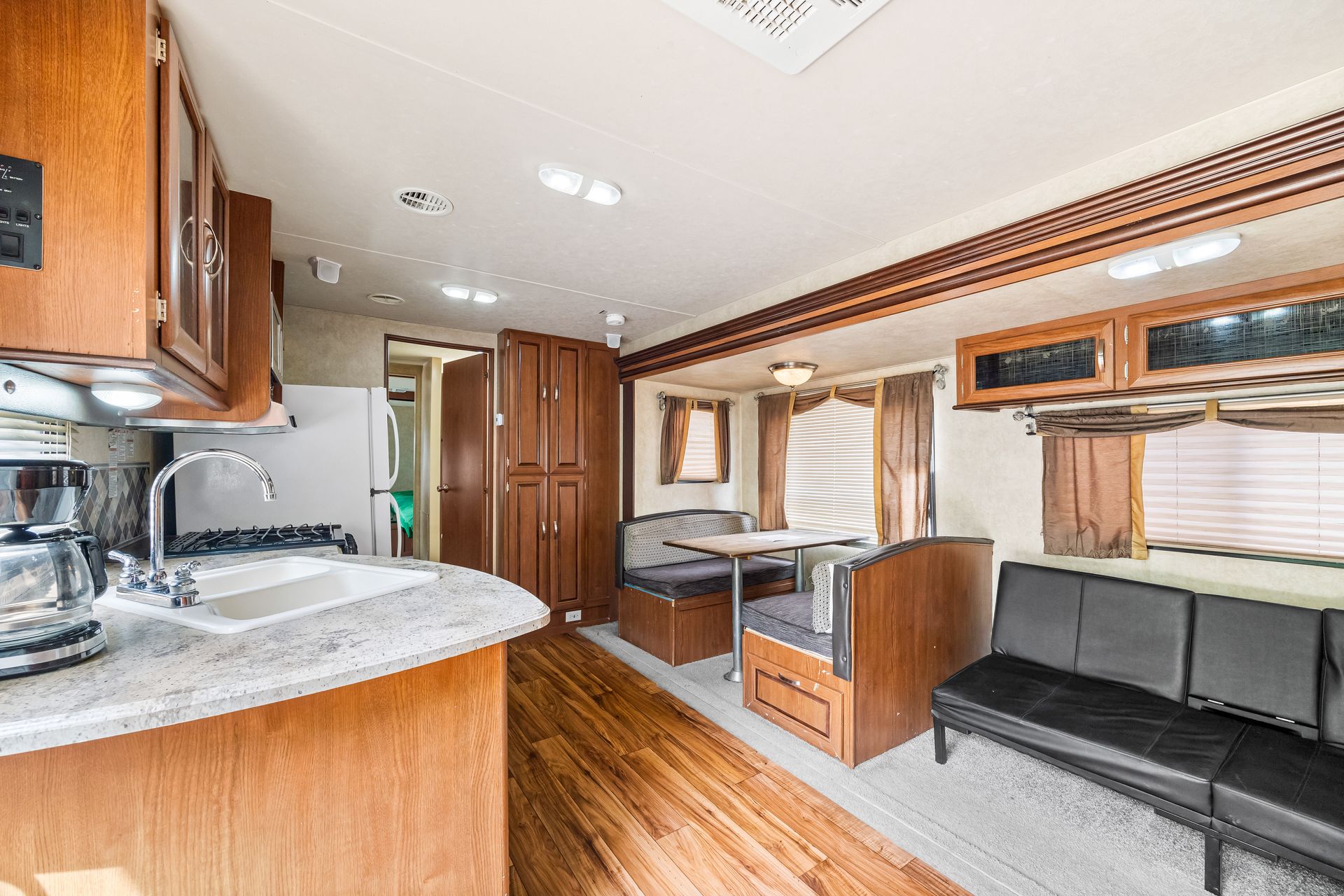 A rv with a kitchen , dining room , and living room.