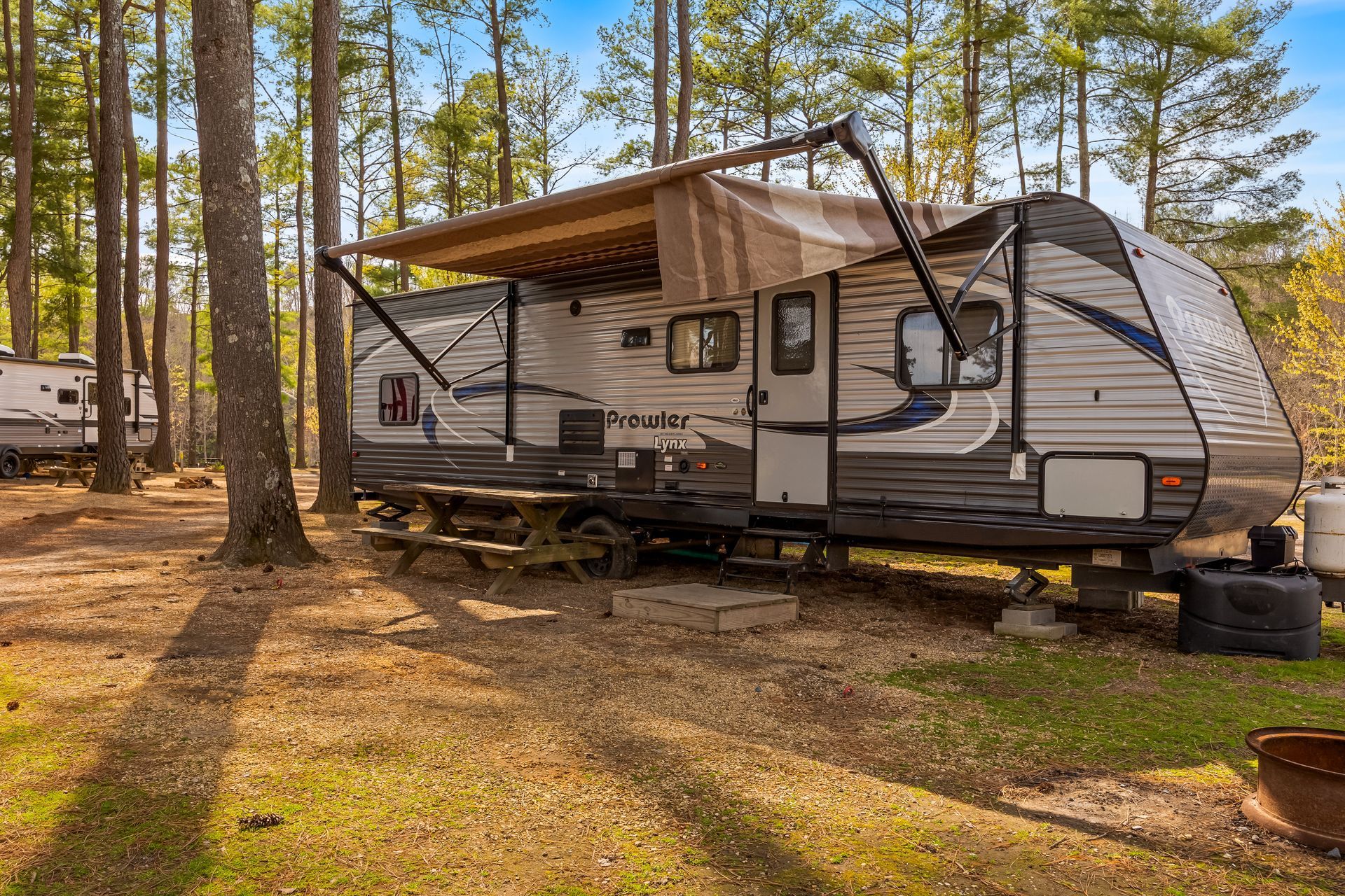 Woman with bunny ears next to a golf cart; person in cart. Trees in the background.