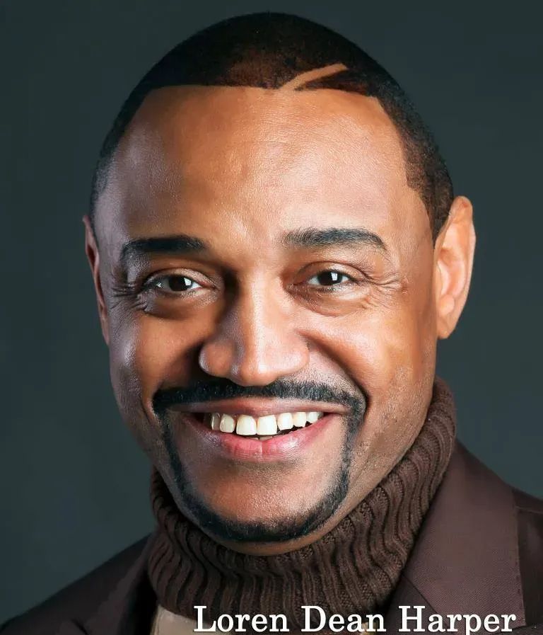 Loren Dean Harper smiling, wearing a brown turtleneck and blazer.