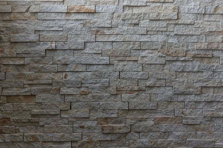 A close up of a stone wall with a brick pattern