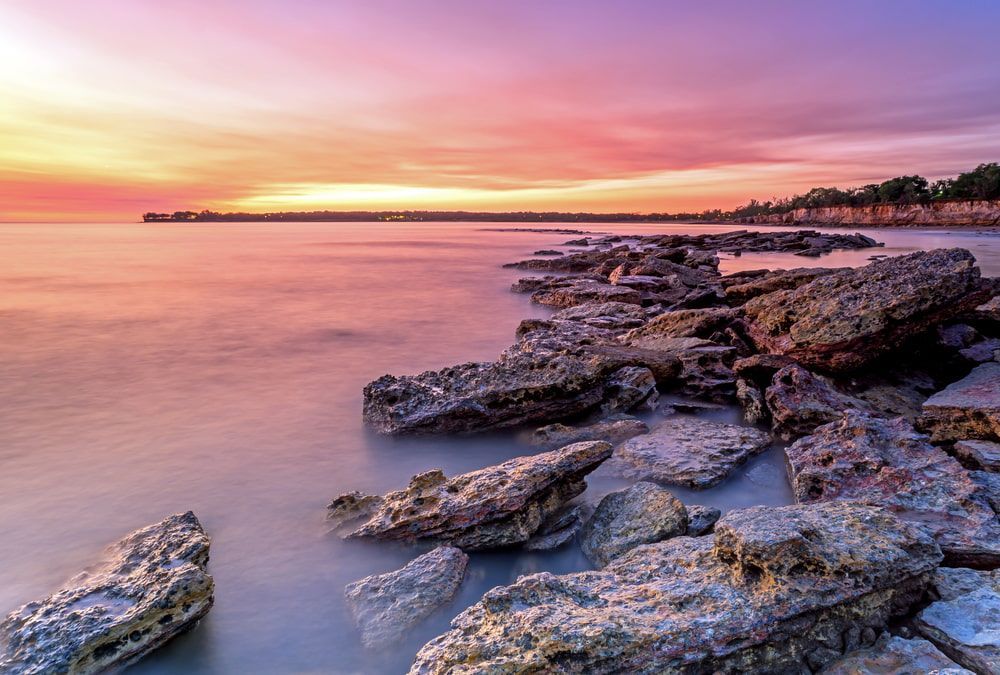 There Is A Sunset Over The Ocean With Rocks In The Foreground — Aust Outback Pest Co In Darwin, NT