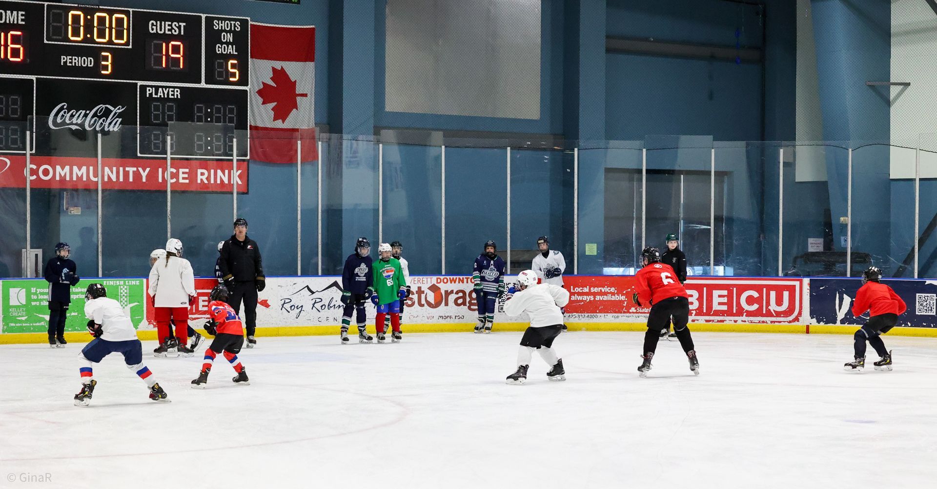 A group of people are playing ice hockey on a rink.