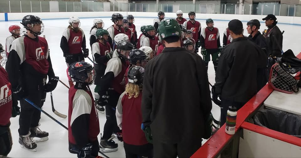 A group of hockey players are huddled together on the ice