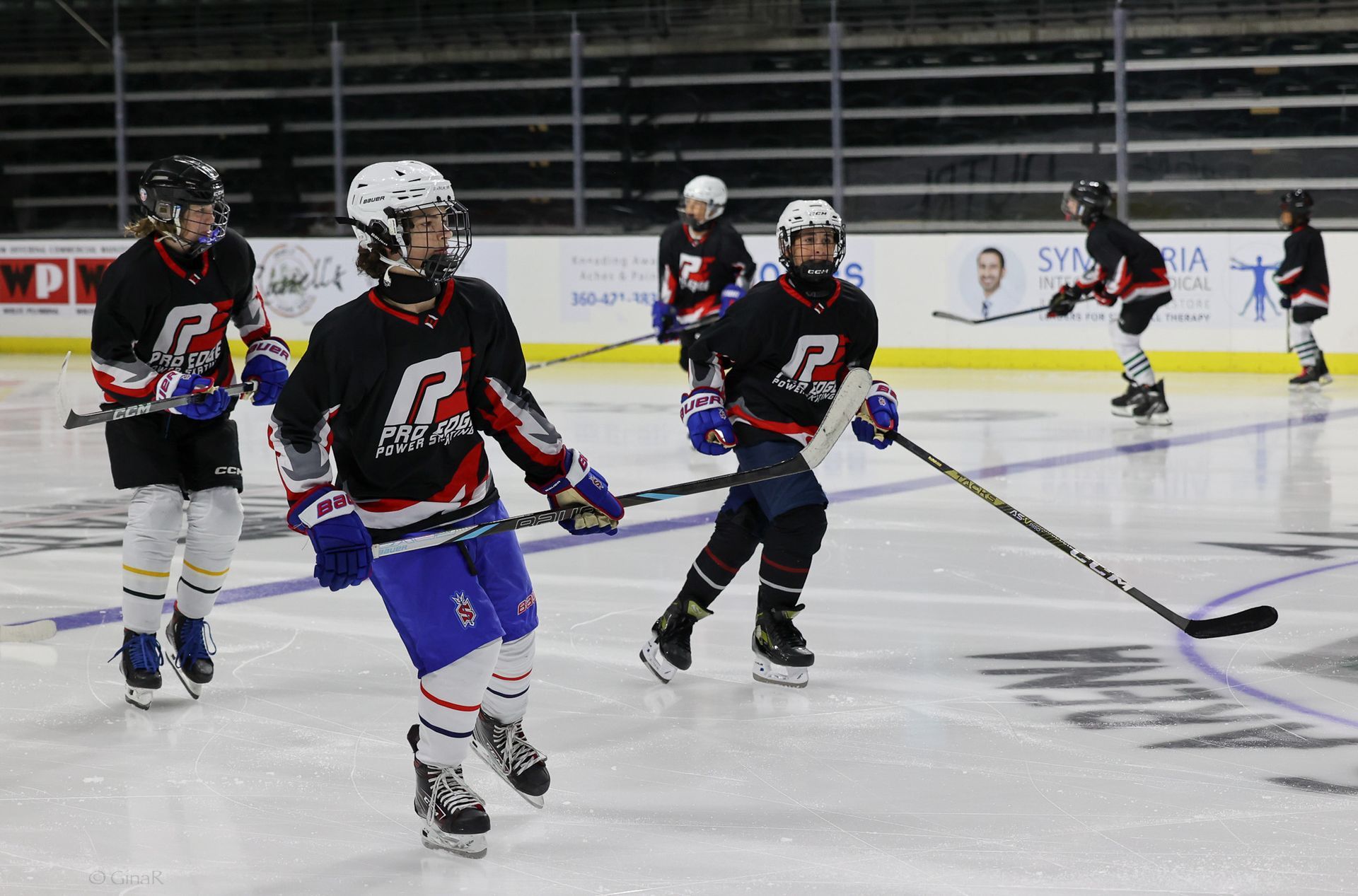 A group of hockey players are playing a game on the ice.