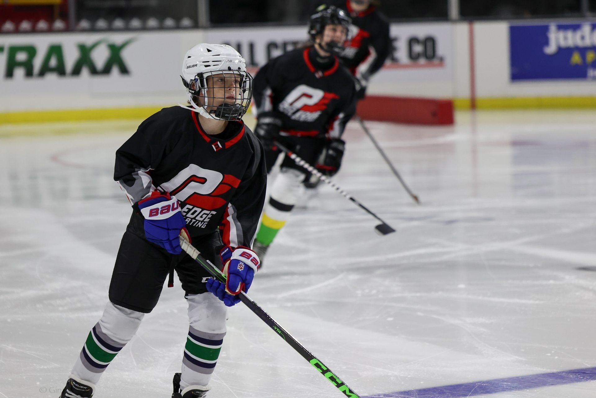 A young boy is holding a hockey stick on the ice.