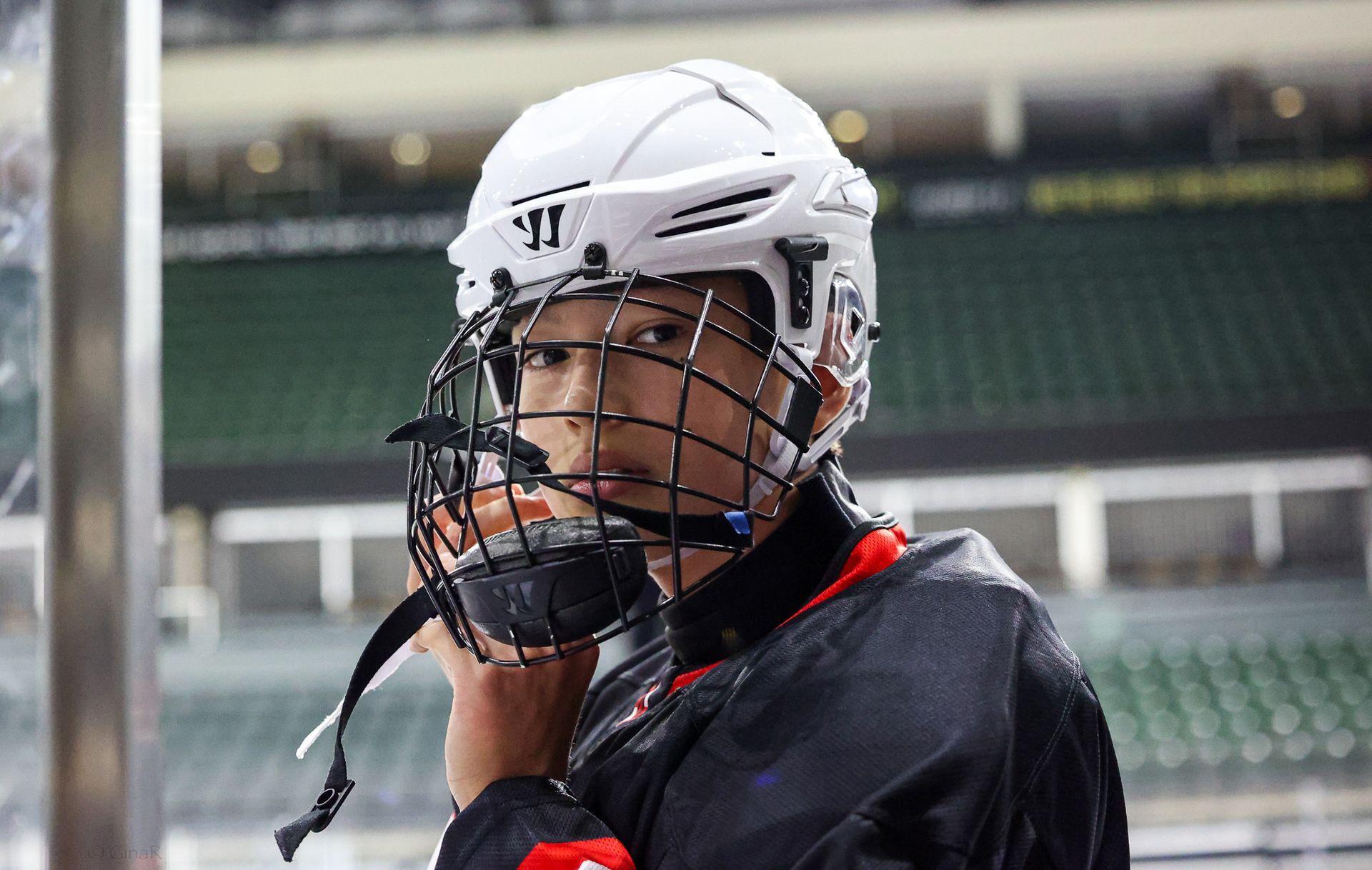 A hockey player is wearing a helmet and a mask.