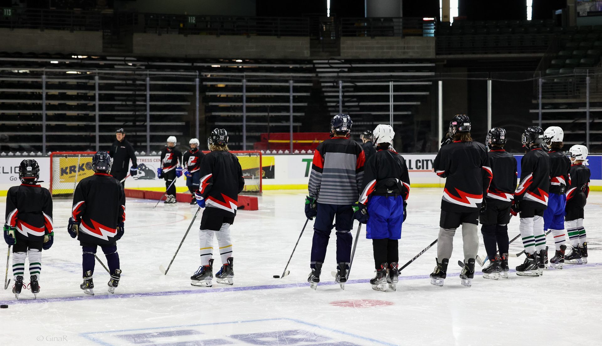 A group of hockey players are practicing on the ice.