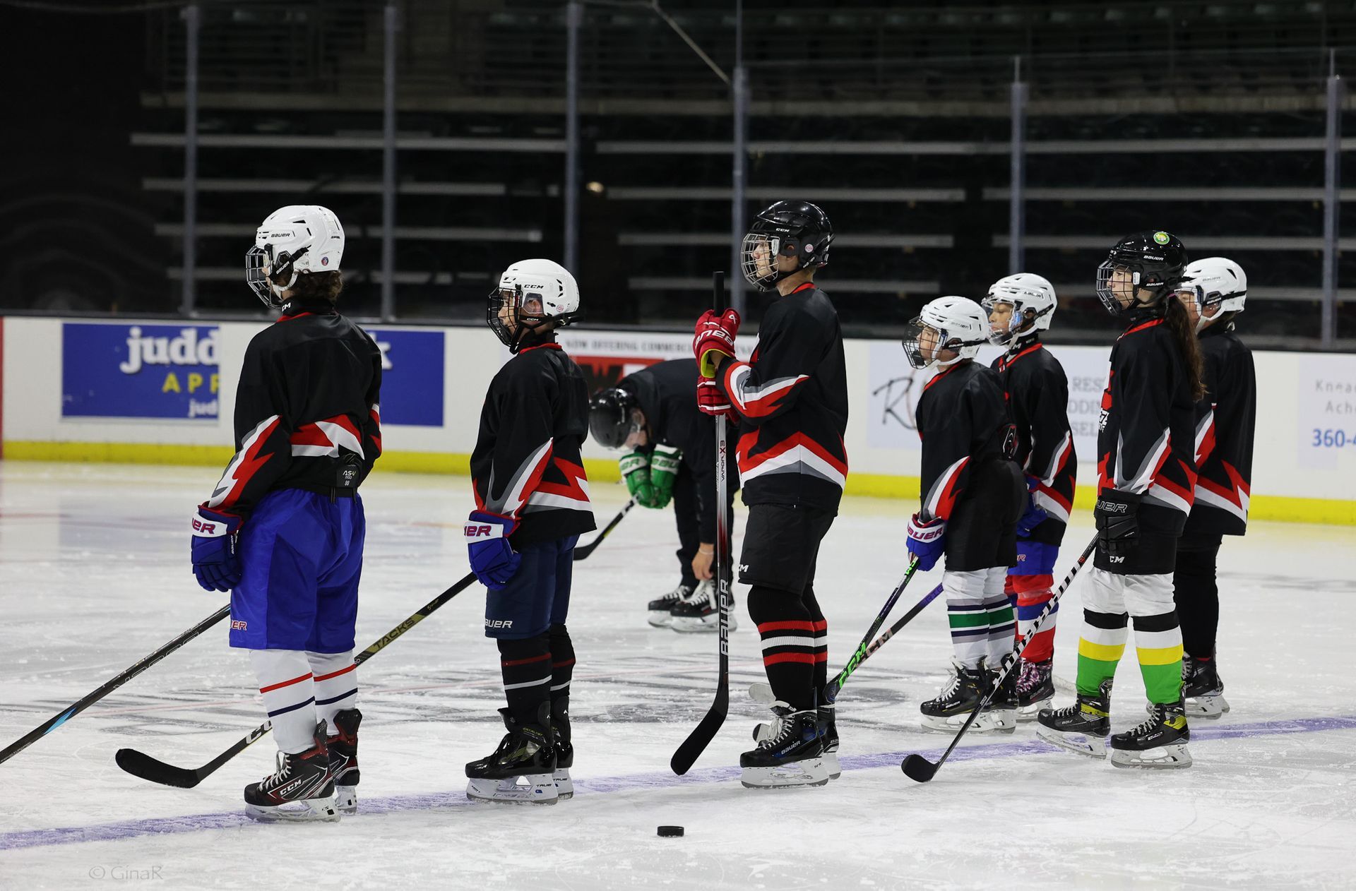 A group of young hockey players are standing on the ice.