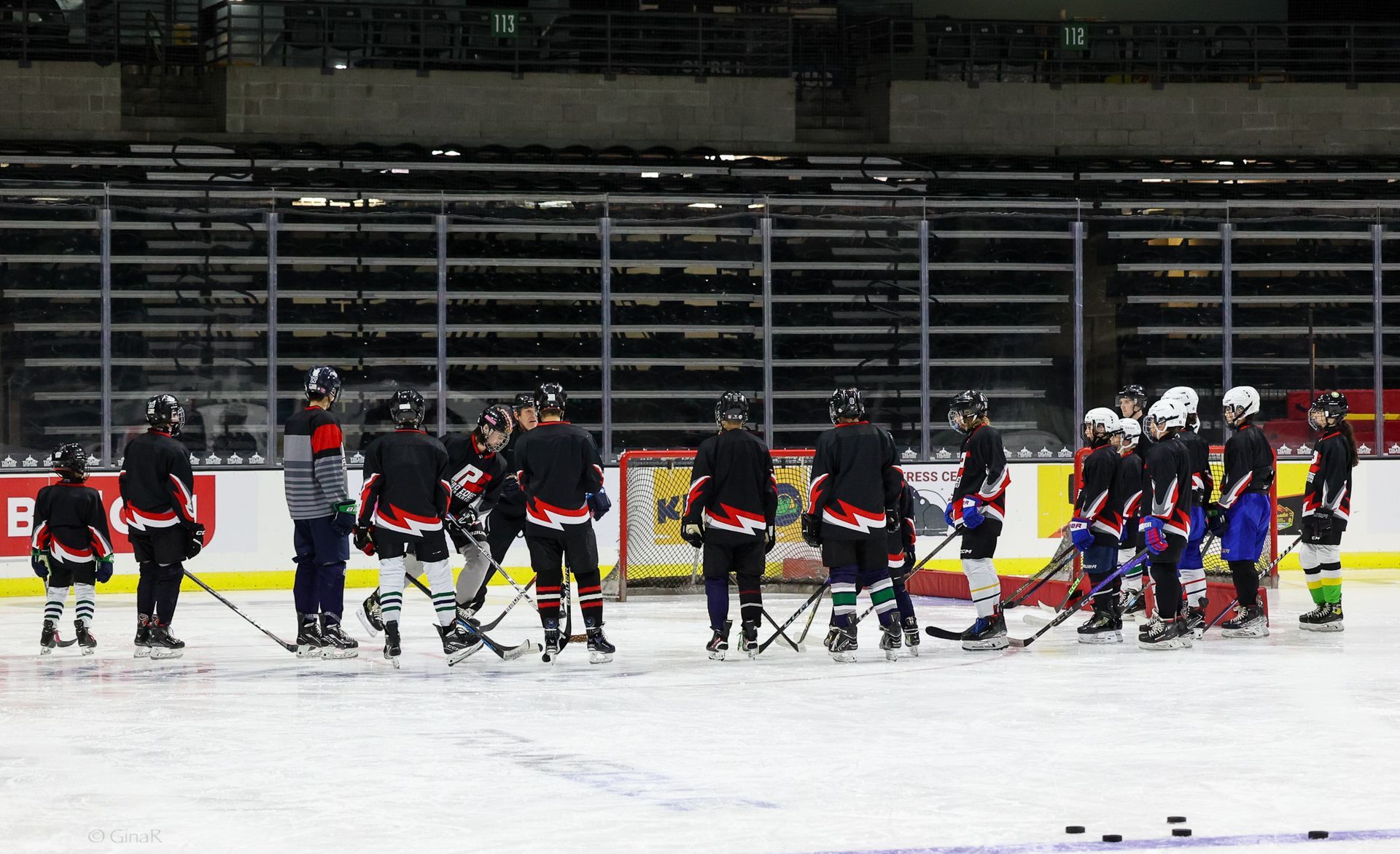 A group of hockey players are standing on the ice in a huddle.