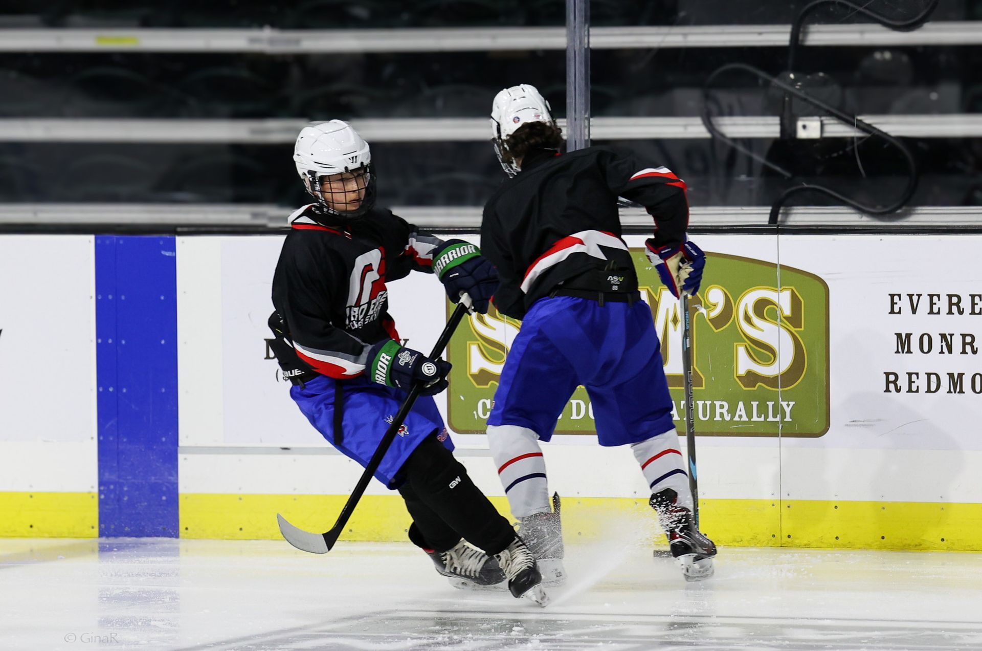 A hockey game is being played in front of a sign that says ' s ' on it