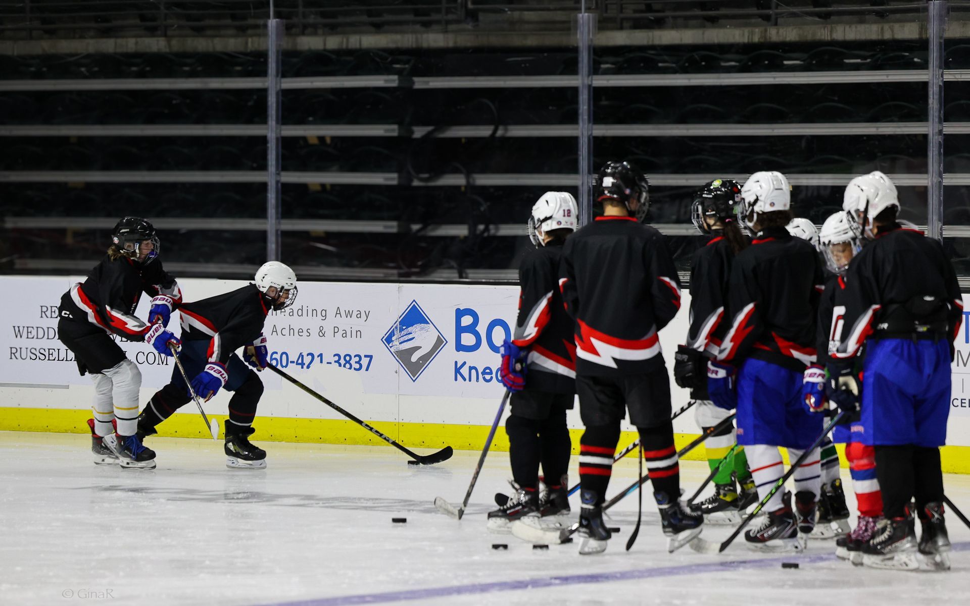 A group of hockey players are huddled together on the ice