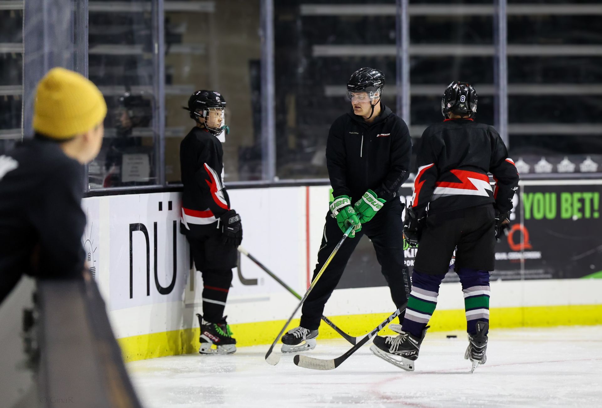 A group of hockey players are practicing on the ice.