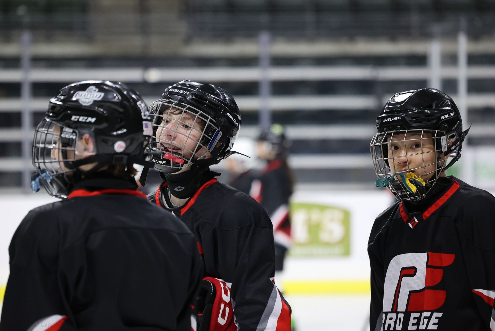 A group of hockey players are standing on the ice talking to each other.