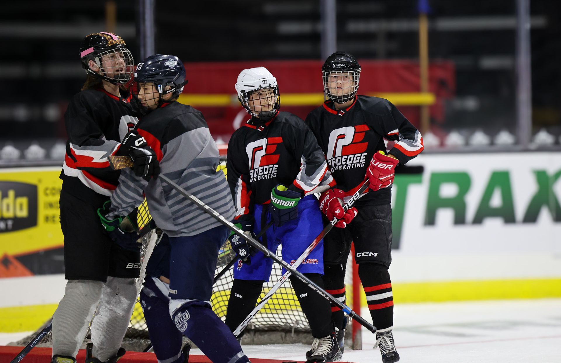 A group of hockey players are playing a game on the ice.