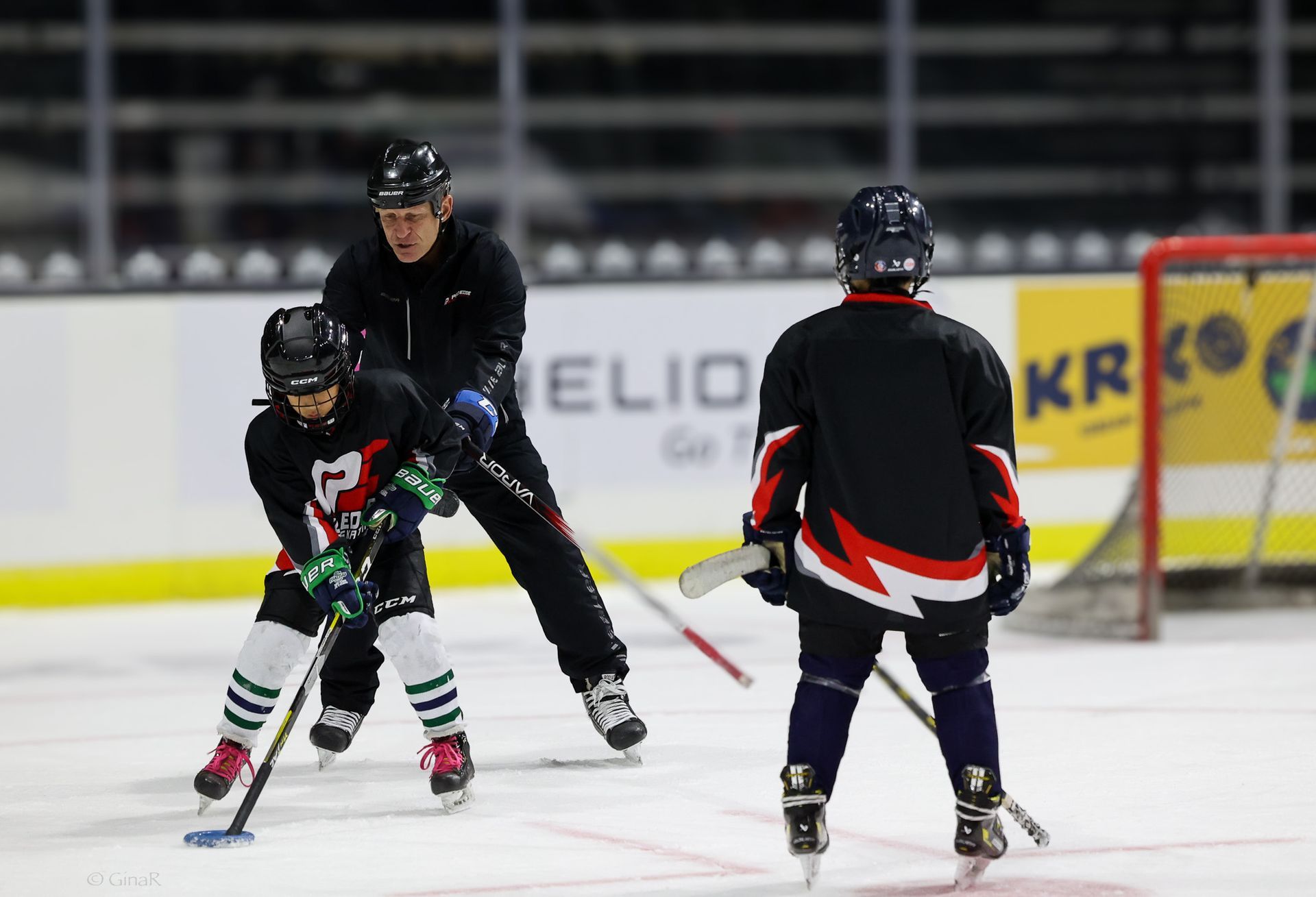 A group of people are playing ice hockey on a rink.