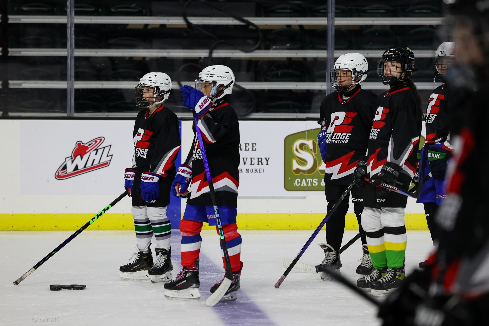 A group of young hockey players are standing on the ice.