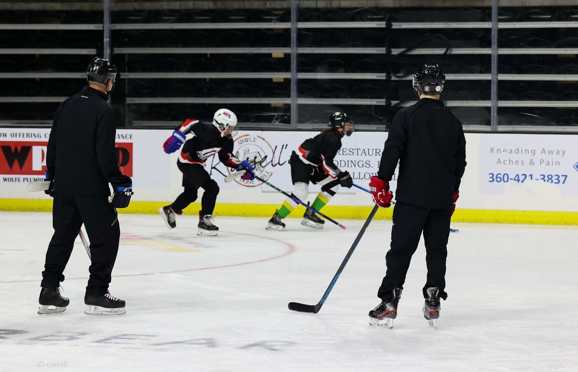 A group of hockey players are practicing on the ice