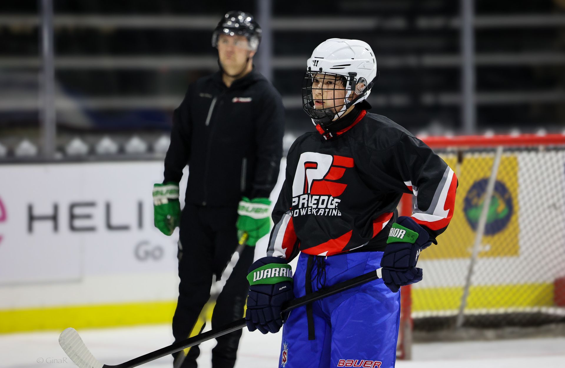 A young boy is holding a hockey stick on the ice.