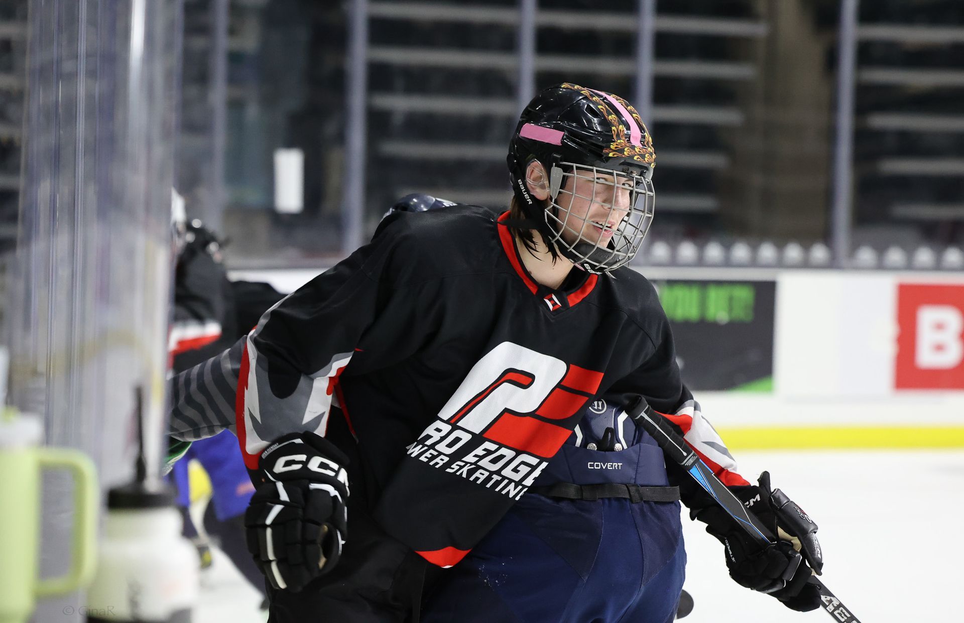 A hockey player wearing a black jersey with the letter p on it