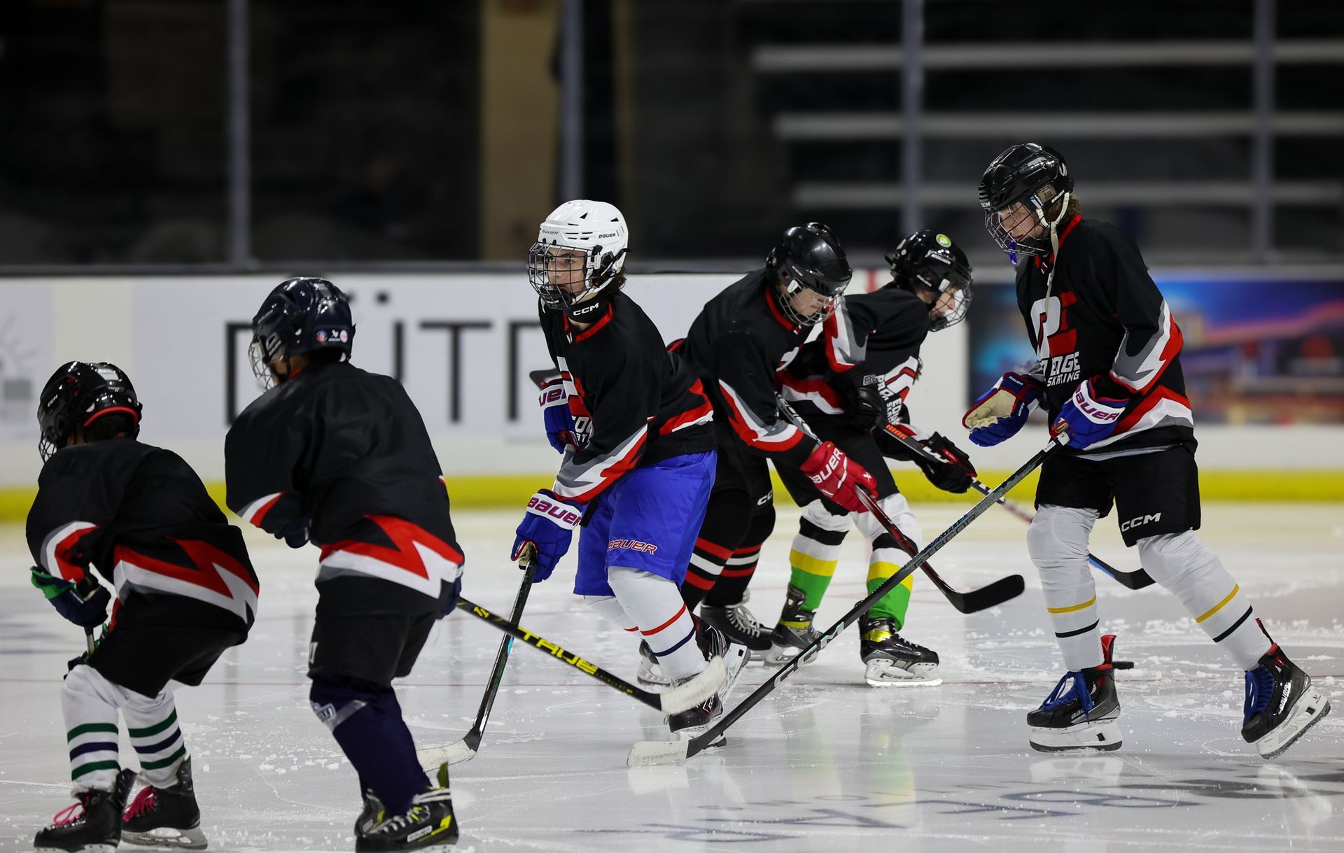 A group of hockey players are playing a game on the ice.