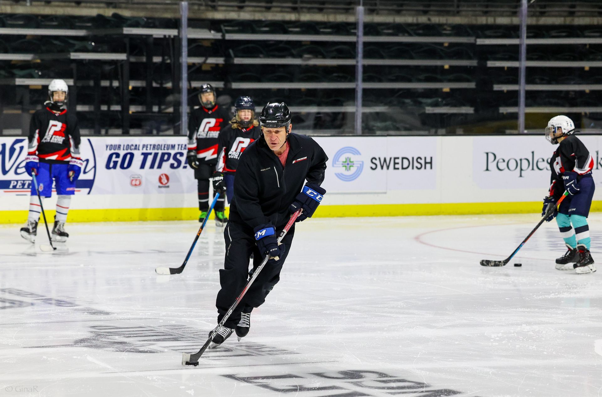 A group of hockey players are playing a game on a rink.