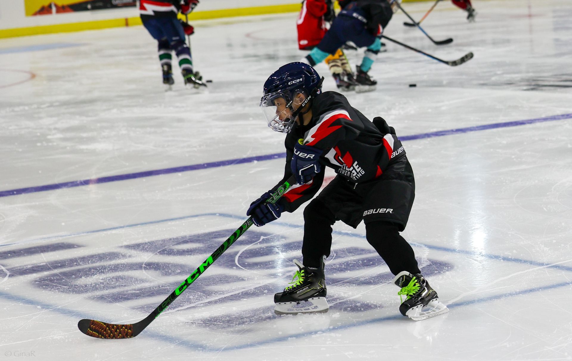 A young boy is playing ice hockey on a rink.
