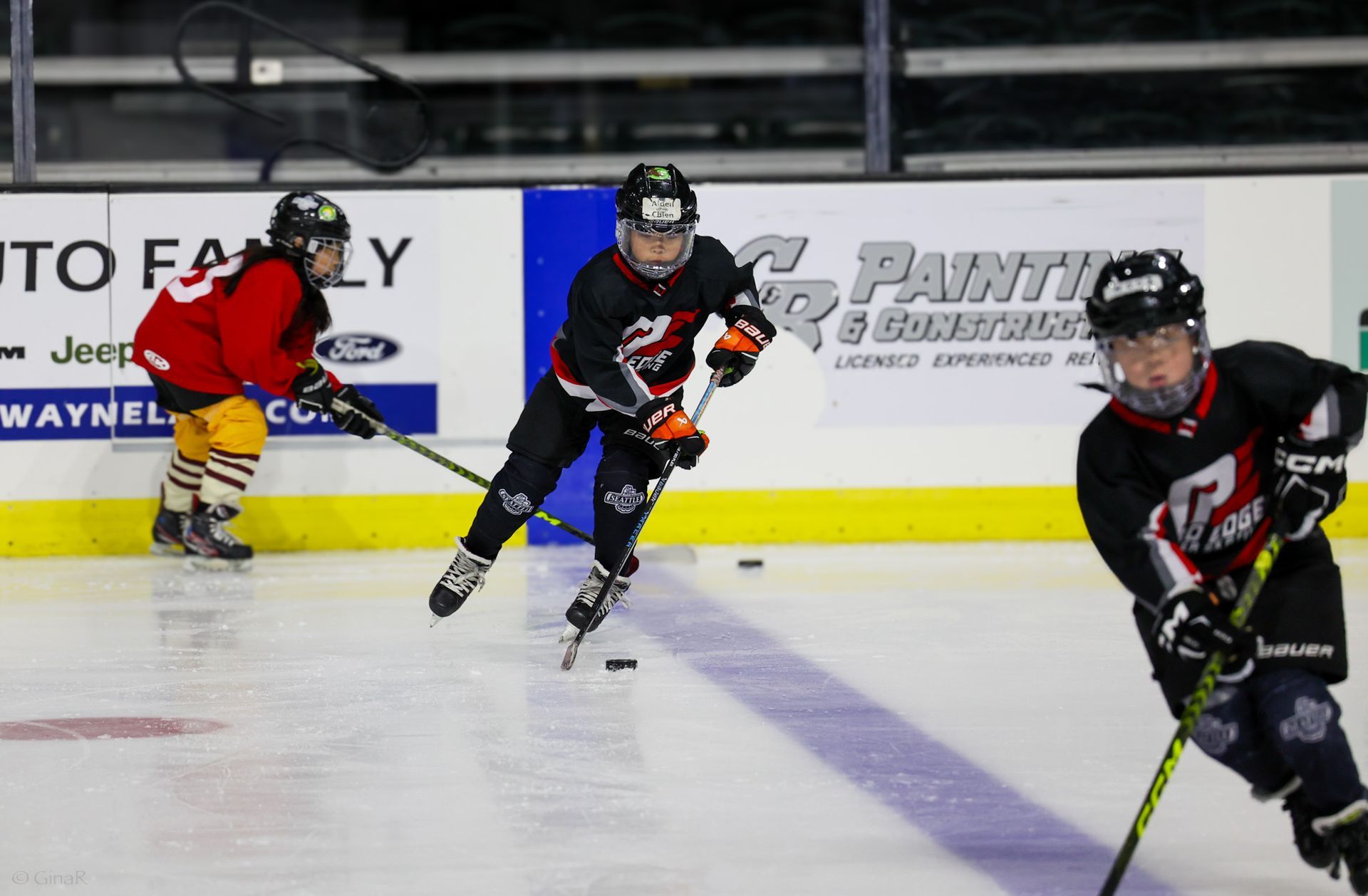 A group of young boys are playing ice hockey on a rink.