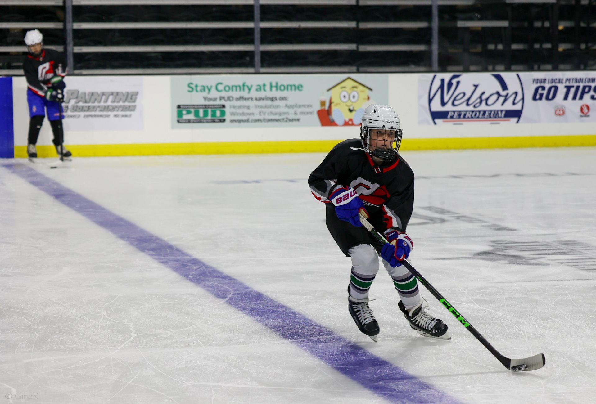 A hockey player is holding a puck on the ice.