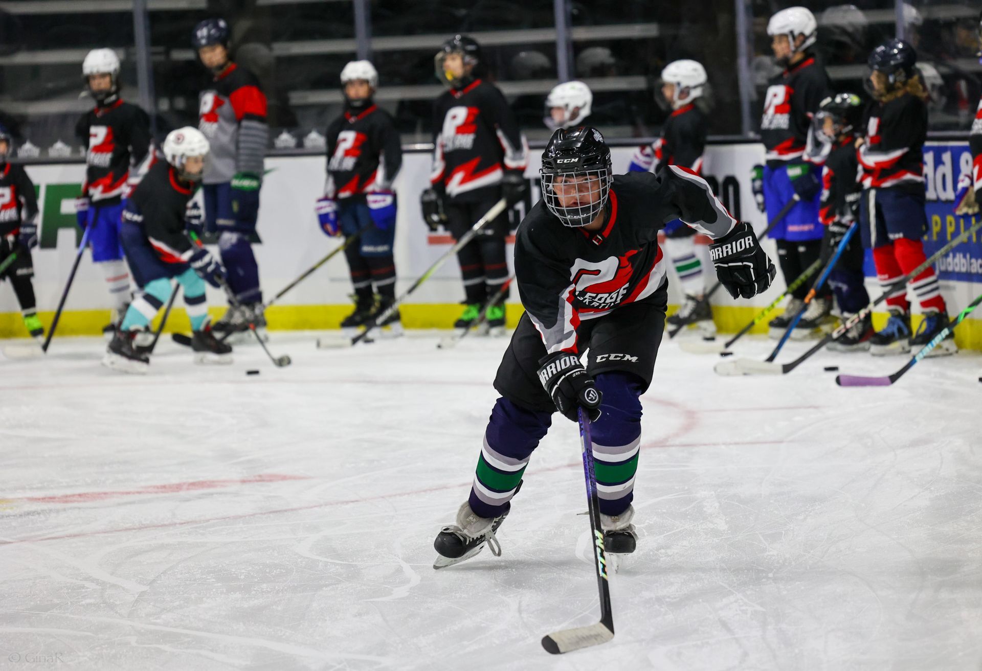 A group of hockey players are practicing on the ice.