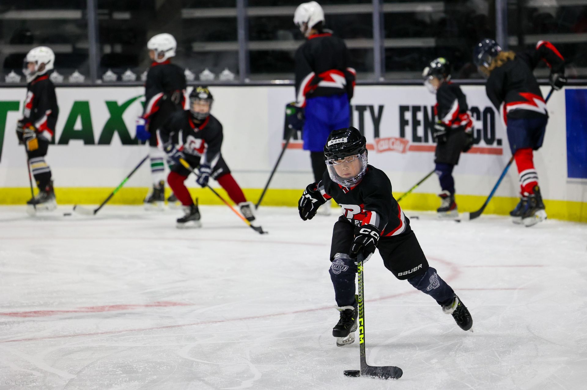 A group of young boys are playing ice hockey on a rink.