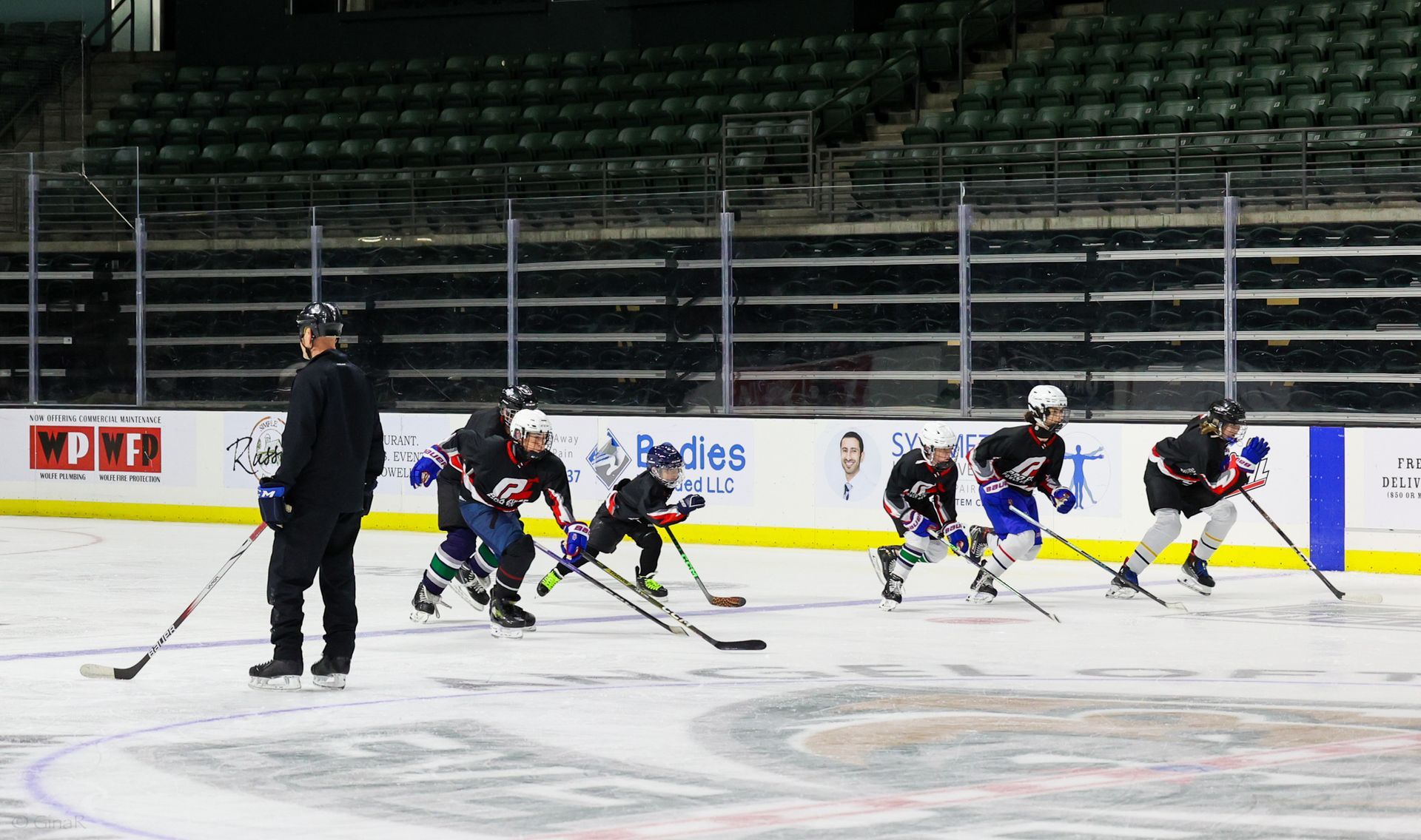 A group of young boys are playing ice hockey on a rink.