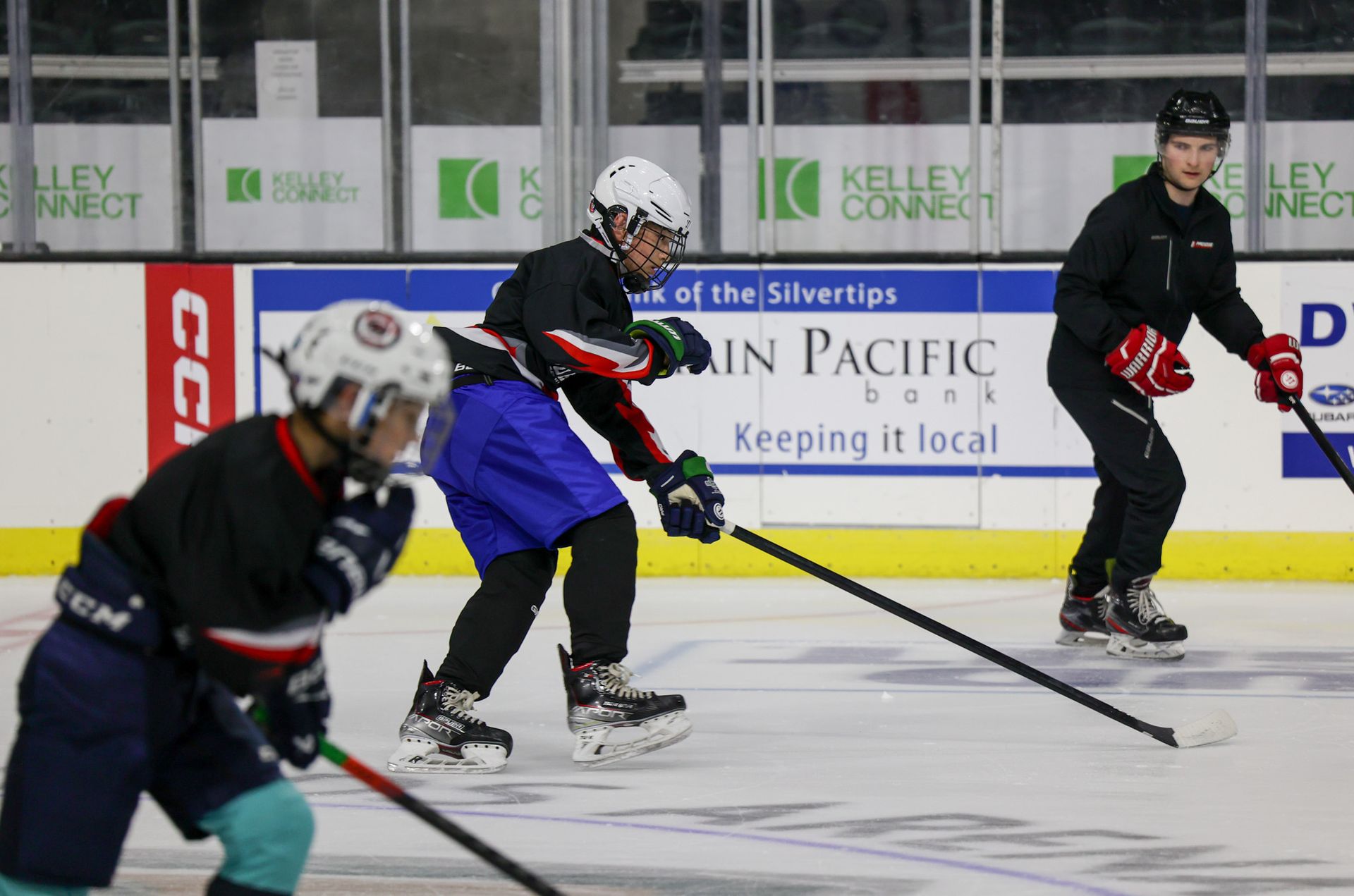 A group of hockey players are playing a game on the ice.