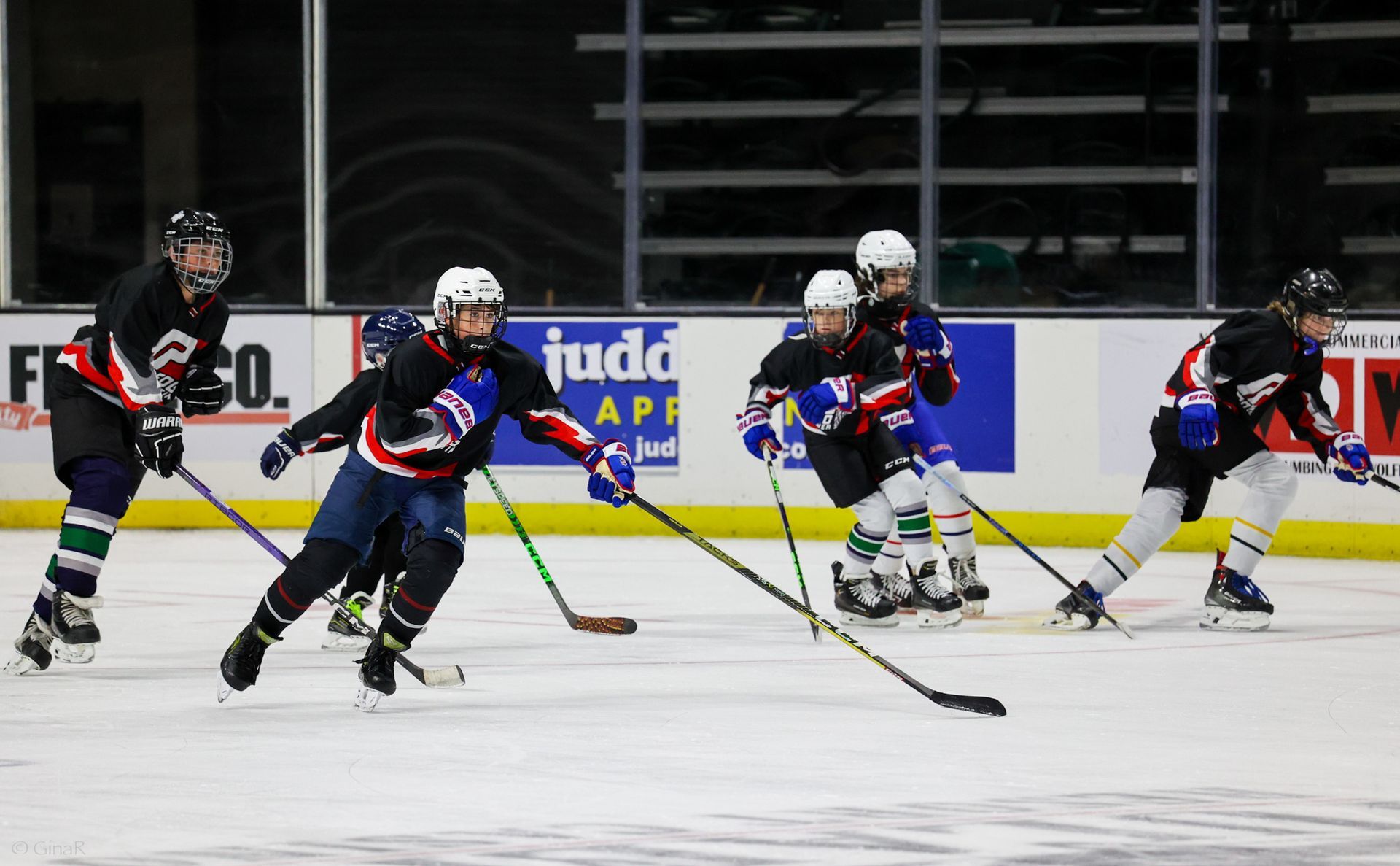 A group of hockey players are playing a game on the ice.
