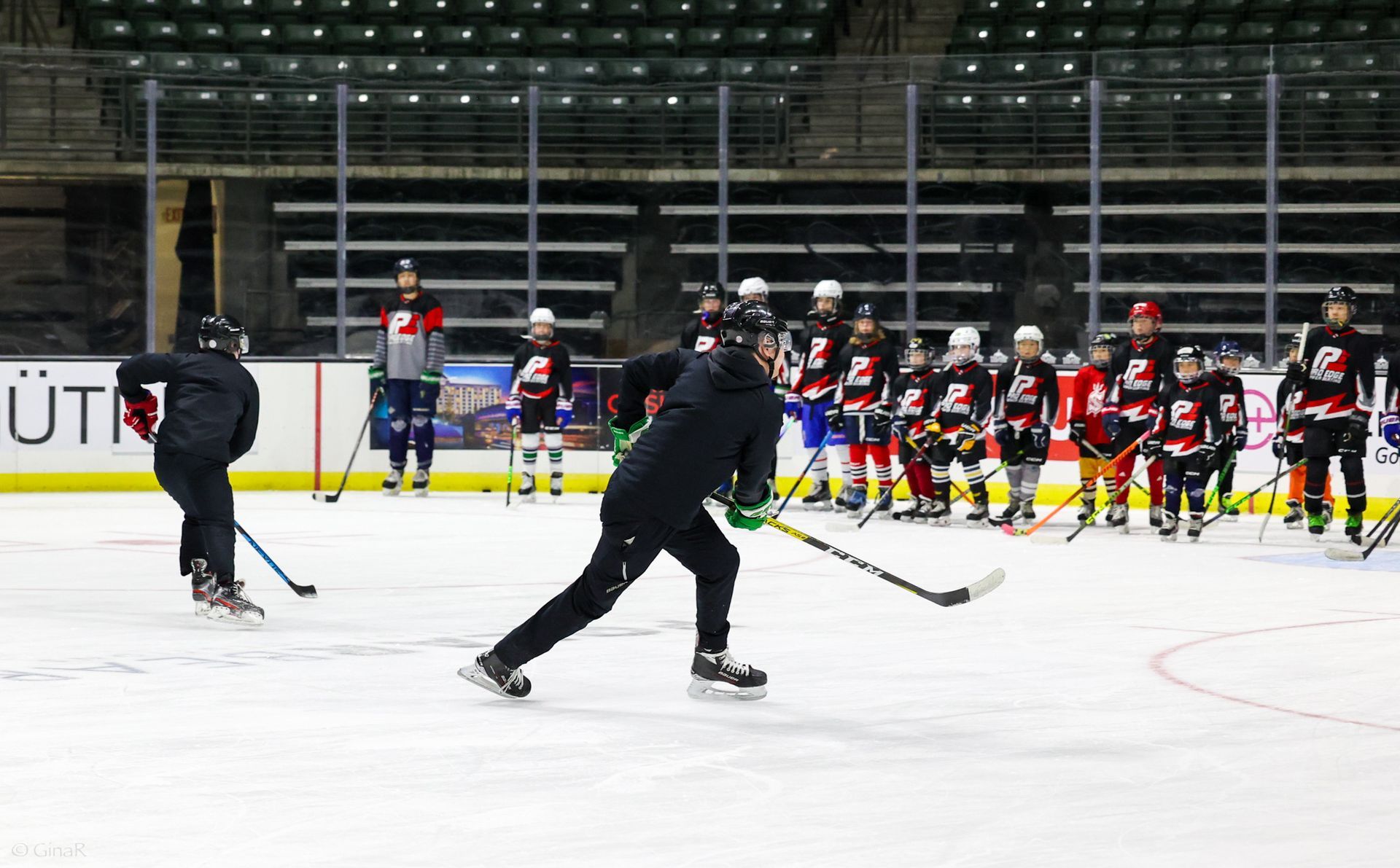 A group of people are playing ice hockey on a rink.