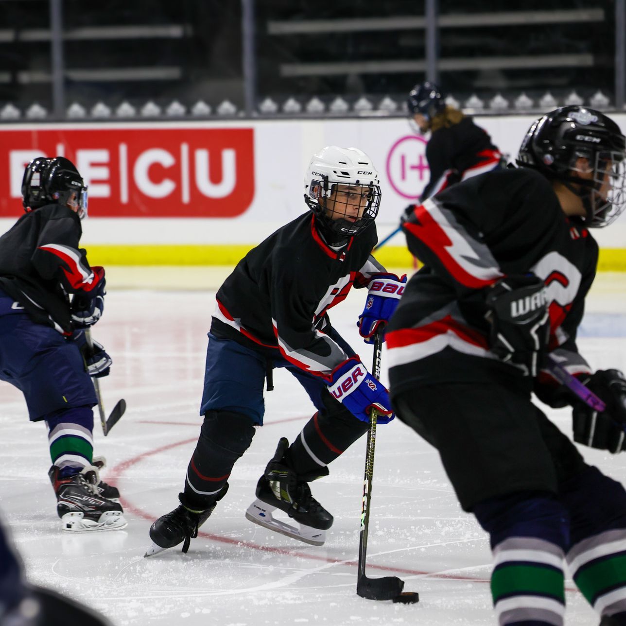 A hockey game is being played in front of a sign