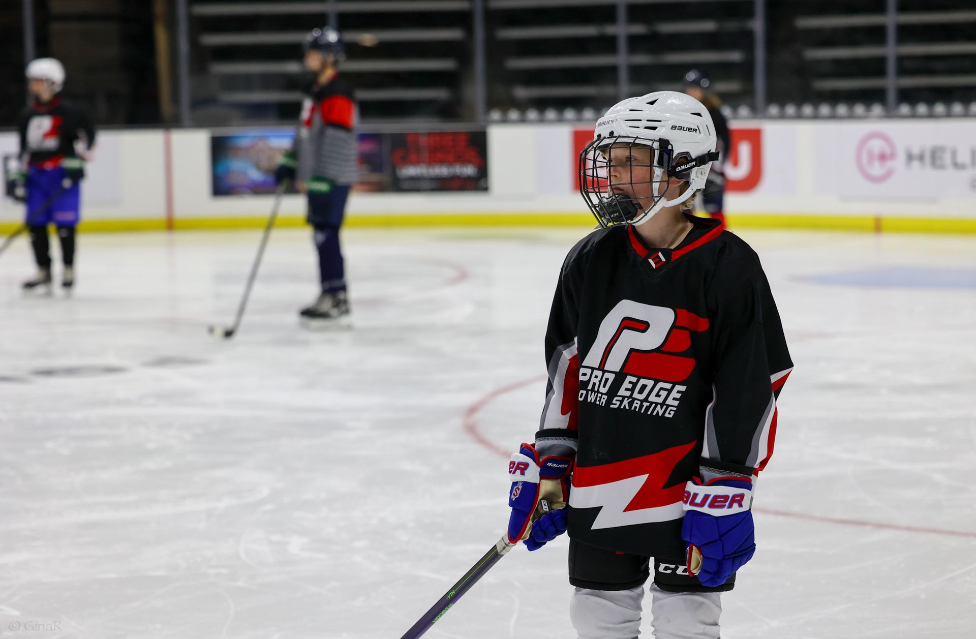 A young boy is holding a hockey stick on the ice.