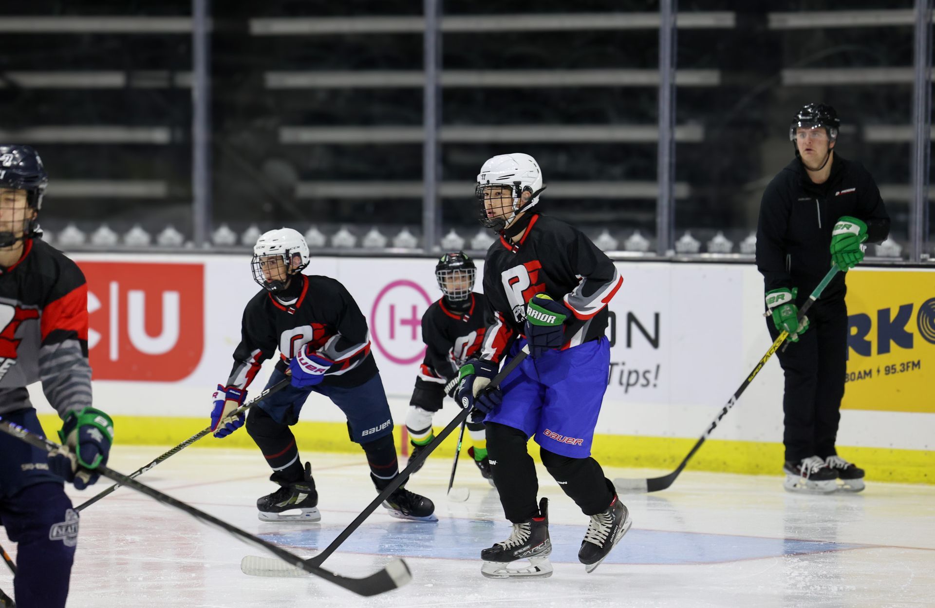 A group of hockey players are playing a game on the ice.