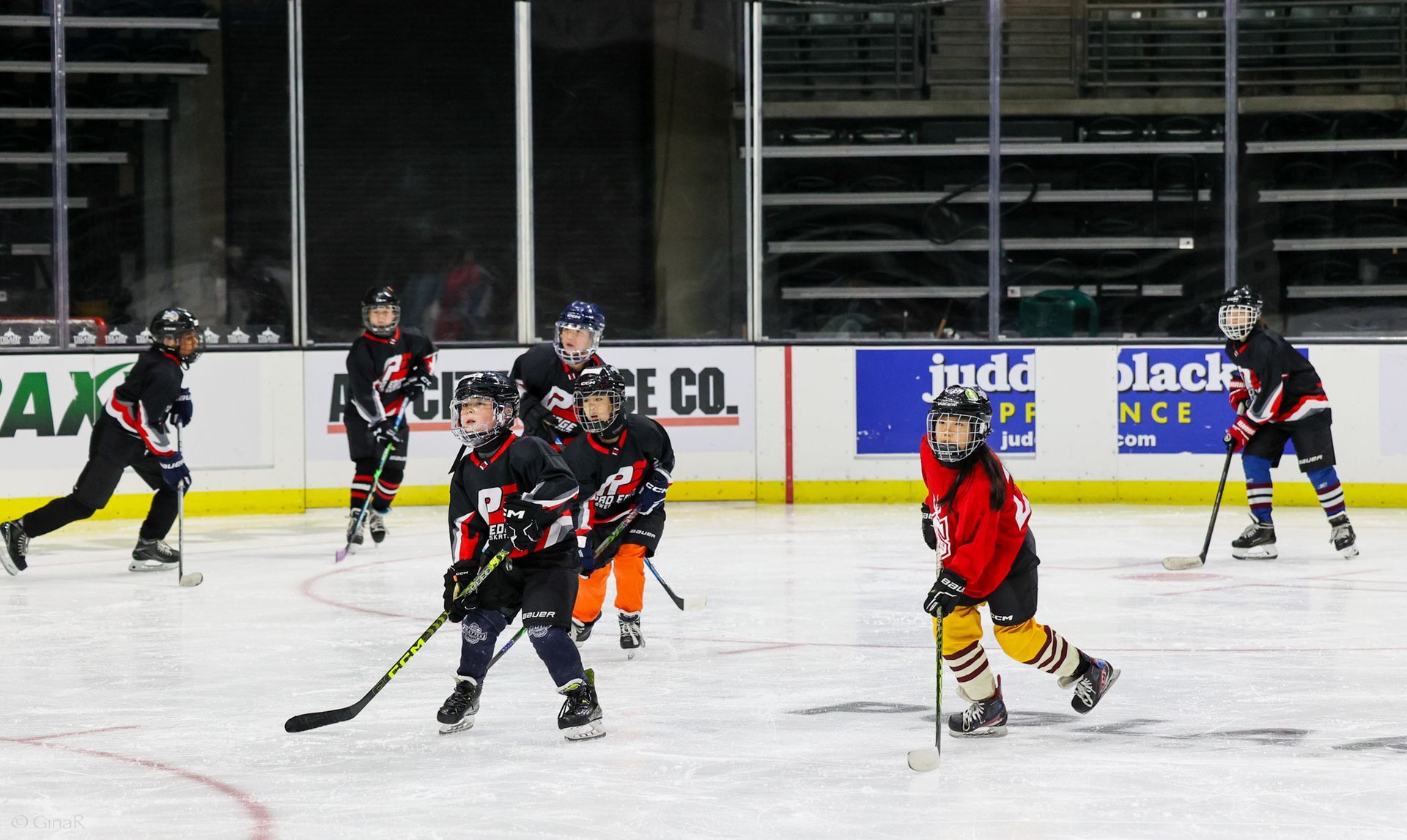 A group of young boys are playing ice hockey on a rink.