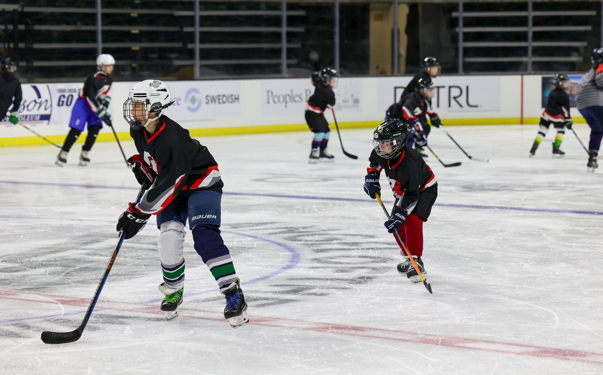 A group of hockey players are playing a game on a rink.