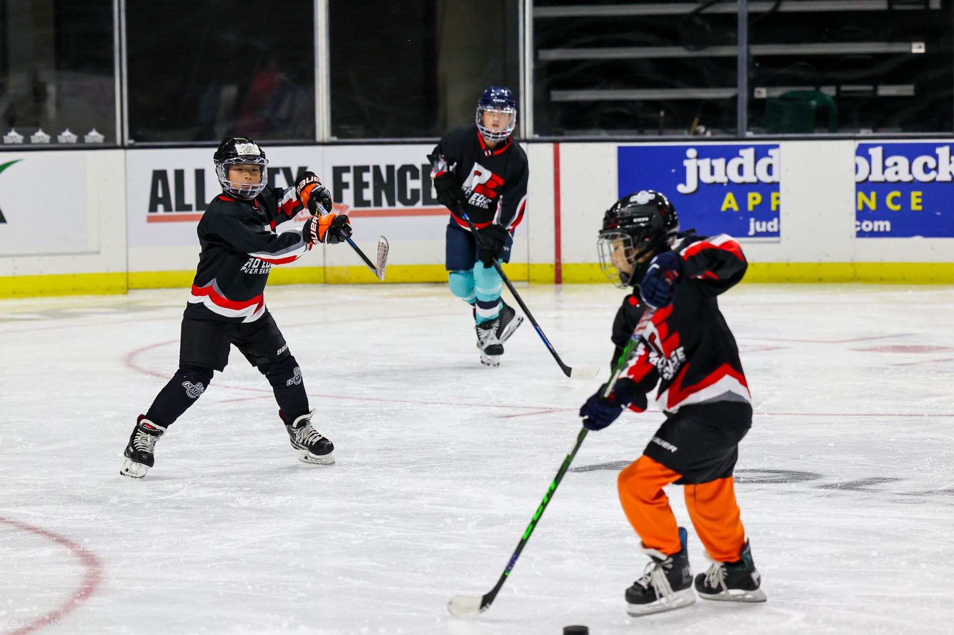 A group of young boys are playing a game of ice hockey.