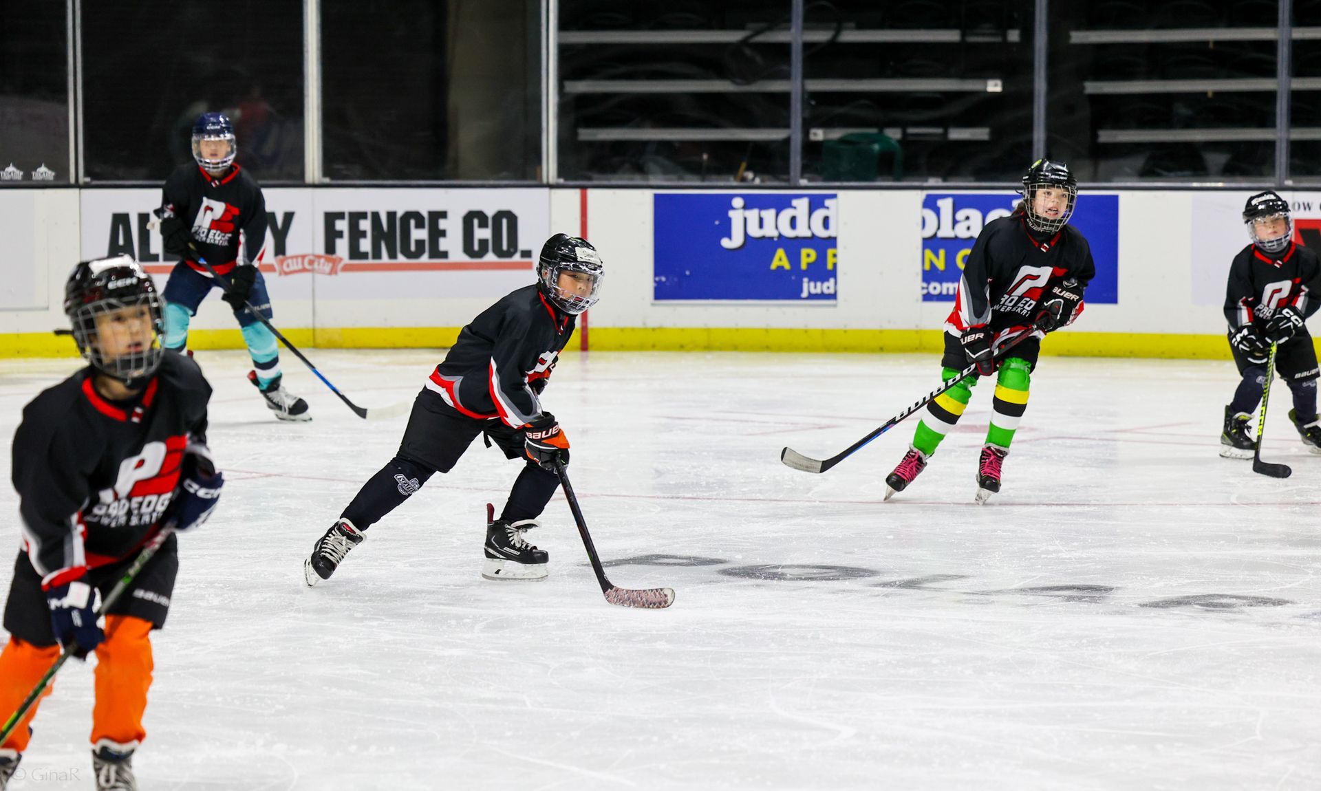 A group of young boys are playing ice hockey on a rink