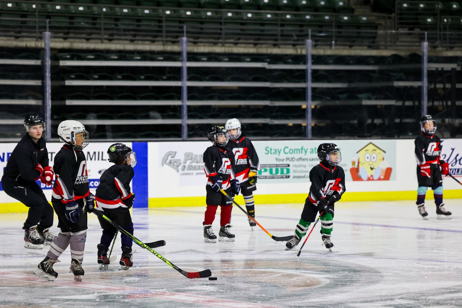 A group of young boys are playing ice hockey on a rink.