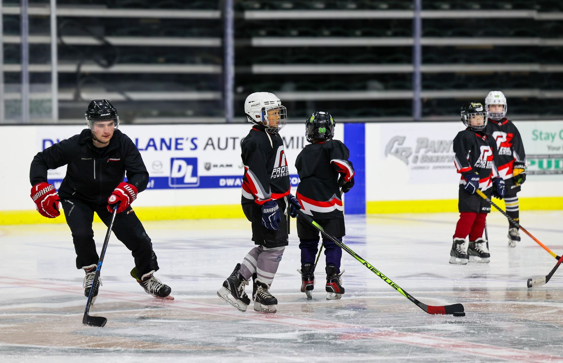 A group of young boys are playing ice hockey on a rink.