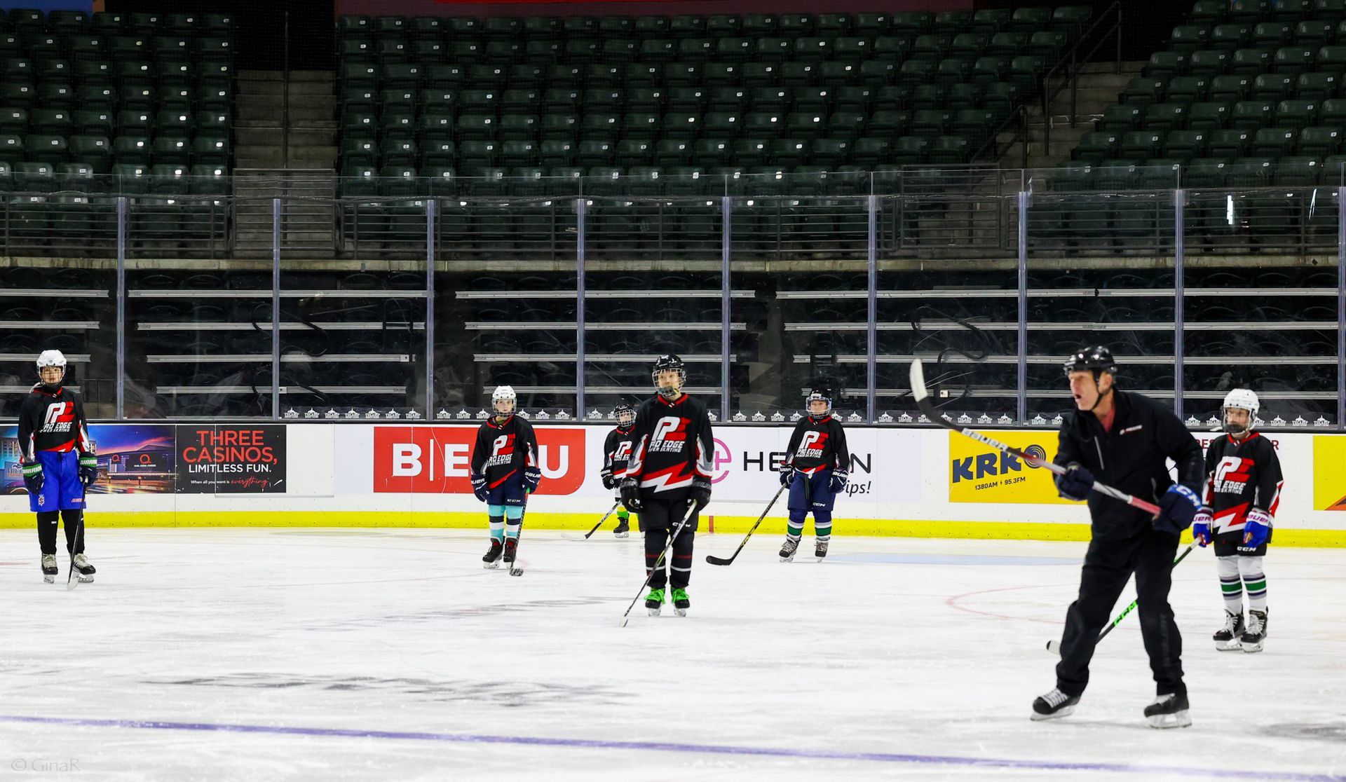 A group of hockey players are practicing on a rink.